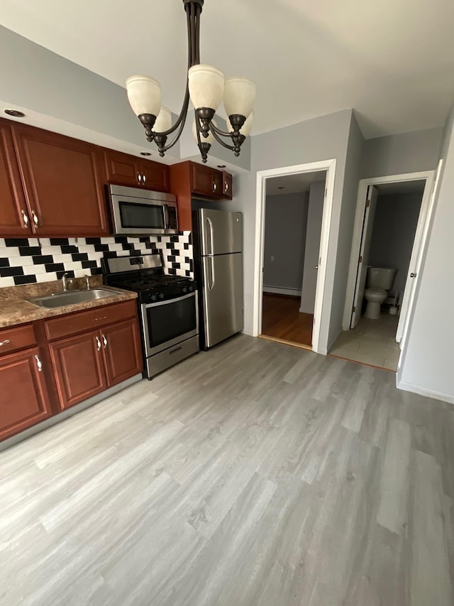 79 W 18th St, Bayonne, NJ 07002 - kitchen with stainless steel appliances, tasteful backsplash, light wood-type flooring, a chandelier, and decorative light fixtures