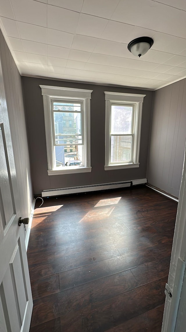 79 W 18th St, Bayonne, NJ 07002 - empty room featuring healthy amount of natural light, baseboard heating, and dark wood-style floors