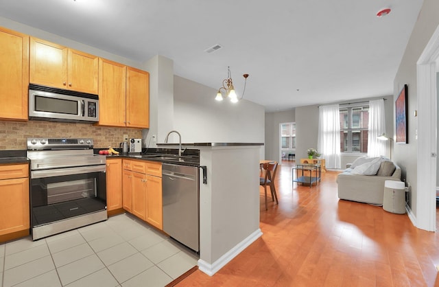 26 Ave At Port Imperial Unit 133, West New York, NJ 07093 - kitchen with stainless steel appliances, a peninsula, open floor plan, dark countertops, and backsplash