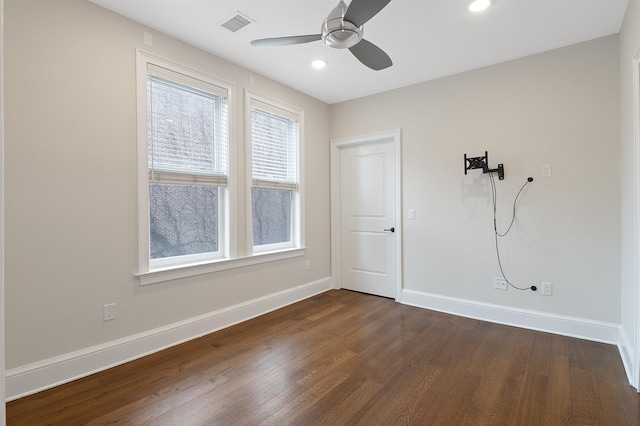 spare room featuring dark wood-type flooring and ceiling fan