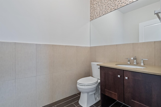 bathroom featuring tile walls, vanity, and toilet