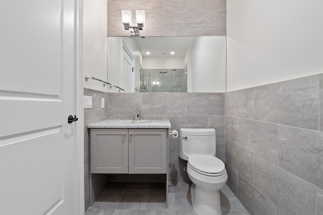 bathroom featuring tile walls, a shower, toilet, and vanity