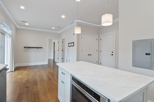 kitchen featuring a center island, electric panel, pendant lighting, ornamental molding, and white cabinetry