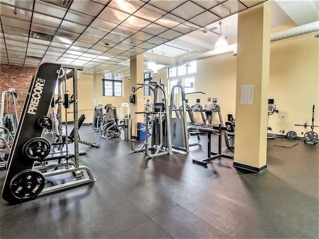 exercise room featuring visible vents, a healthy amount of sunlight, and baseboards