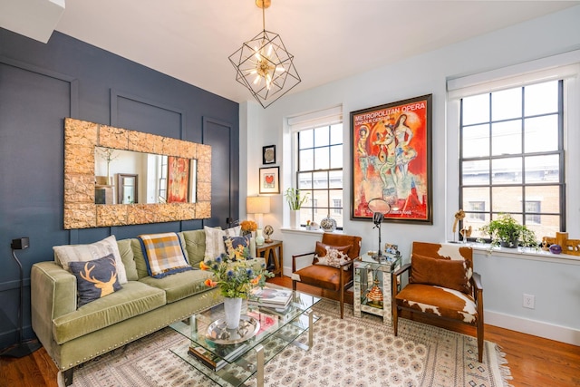 sitting room featuring a notable chandelier, baseboards, and wood finished floors