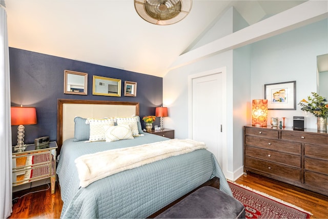 bedroom with vaulted ceiling, baseboards, and wood finished floors