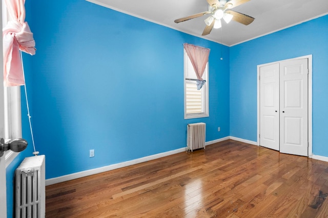 15 9th St, Bayonne, NJ 07002 - unfurnished bedroom with radiator heating unit, wood finished floors, baseboards, ornamental molding, and ceiling fan