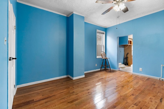 15 9th St, Bayonne, NJ 07002 - unfurnished bedroom featuring a textured ceiling, hardwood / wood-style floors, ornamental molding, baseboards, and a ceiling fan