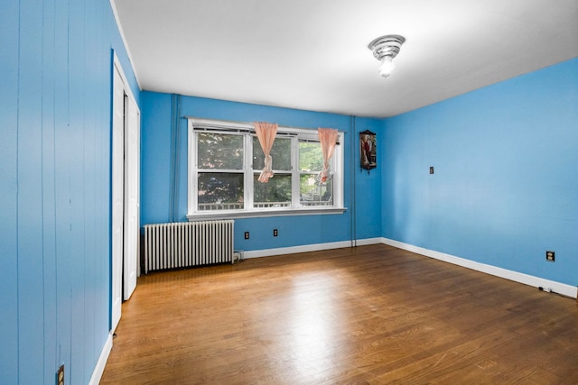 15 9th St, Bayonne, NJ 07002 - unfurnished room with radiator, wood finished floors, and baseboards