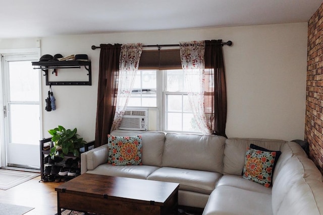 living room featuring brick wall and wood finished floors