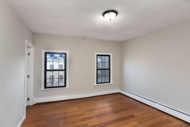 23 Westervelt Pl, Jersey City, NJ 07304 - spare room featuring baseboards, hardwood / wood-style flooring, a baseboard radiator, and a textured ceiling