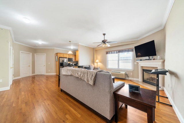 301 68th St Unit 8, Guttenberg, NJ 07093 - living room with a fireplace with flush hearth, light wood-type flooring, a wall mounted air conditioner, ceiling fan, and ornamental molding