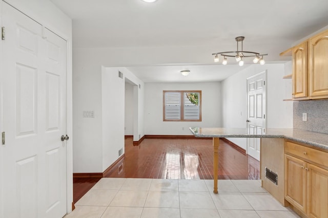 16 Hazel Ave, Livingston, NJ 07039 - kitchen featuring light brown cabinets, light wood-style flooring, decorative backsplash, baseboards, and light stone counters