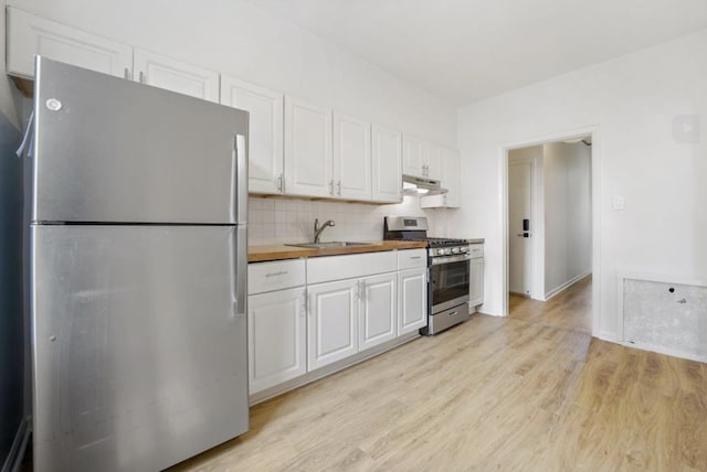 75 Reservoir Ave, Jersey City, NJ 07307 - kitchen featuring stainless steel appliances, butcher block counters, white cabinets, under cabinet range hood, and light wood finished floors