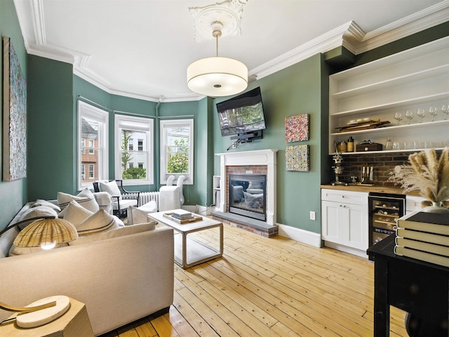 75 Reservoir Ave, Jersey City, NJ 07307 - living area with bar area, wine cooler, a fireplace, crown molding, and light wood-type flooring