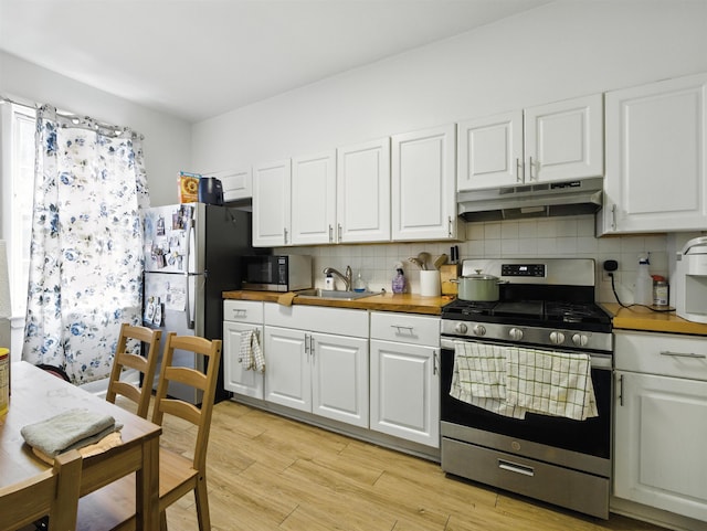75 Reservoir Ave, Jersey City, NJ 07307 - kitchen with appliances with stainless steel finishes, under cabinet range hood, backsplash, and white cabinetry