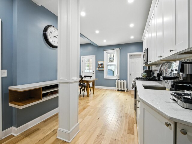 75 Reservoir Ave, Jersey City, NJ 07307 - kitchen featuring radiator, stainless steel microwave, light wood finished floors, white cabinets, and recessed lighting