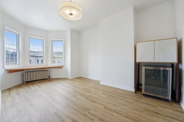 75 Reservoir Ave, Jersey City, NJ 07307 - unfurnished living room featuring radiator heating unit, wood finished floors, and beverage cooler