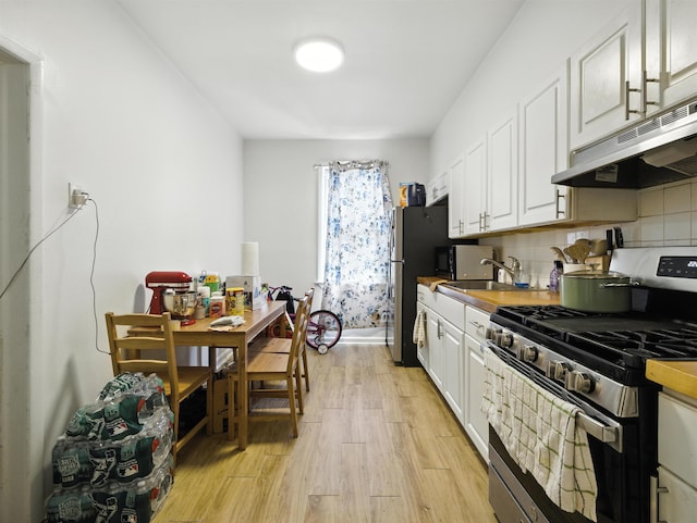 75 Reservoir Ave, Jersey City, NJ 07307 - kitchen featuring stainless steel appliances, under cabinet range hood, light wood-style flooring, white cabinets, and decorative backsplash