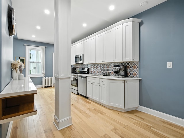75 Reservoir Ave, Jersey City, NJ 07307 - kitchen with radiator heating unit, stainless steel appliances, backsplash, white cabinets, and recessed lighting