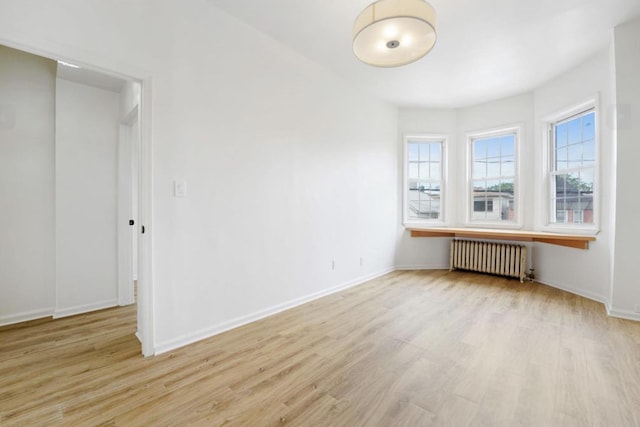 75 Reservoir Ave, Jersey City, NJ 07307 - empty room with radiator heating unit and light wood-type flooring