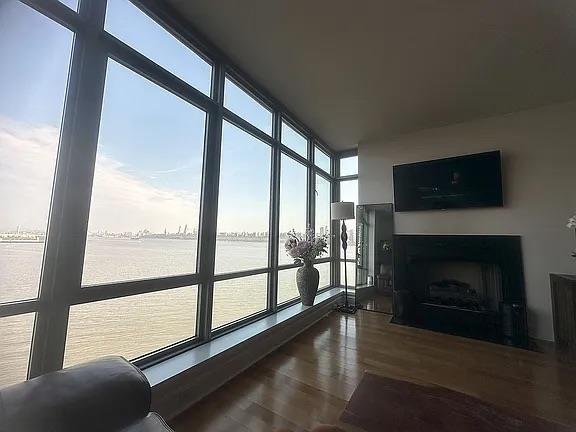 sunroom featuring a water view