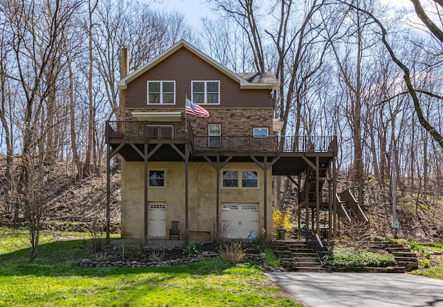 view of front of property with a front lawn, a deck, and a garage