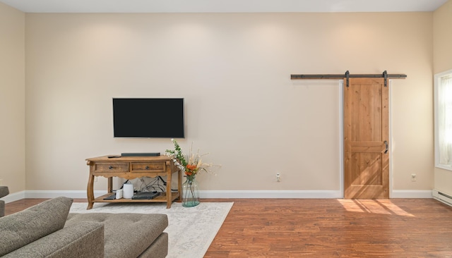 living room with a barn door and wood-type flooring