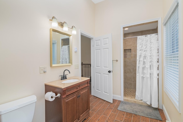 bathroom featuring vanity, toilet, and walk in shower