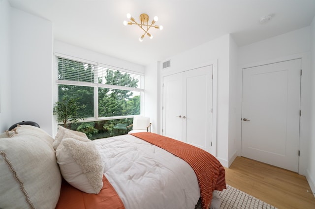 414 1st St Unit 5, Jersey City, NJ 07302 - bedroom with light wood-type flooring, a chandelier, and a closet
