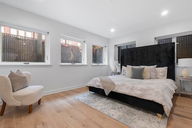 bedroom featuring light hardwood / wood-style flooring and multiple windows