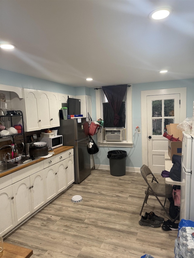 4312 Cottage St, North Bergen, NJ 07047 - kitchen with white microwave, freestanding refrigerator, white cabinets, recessed lighting, and cooling unit