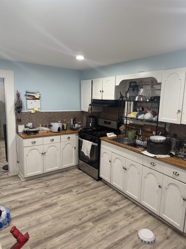 4312 Cottage St, North Bergen, NJ 07047 - kitchen with stainless steel gas range, wooden counters, white cabinets, decorative backsplash, and ventilation hood