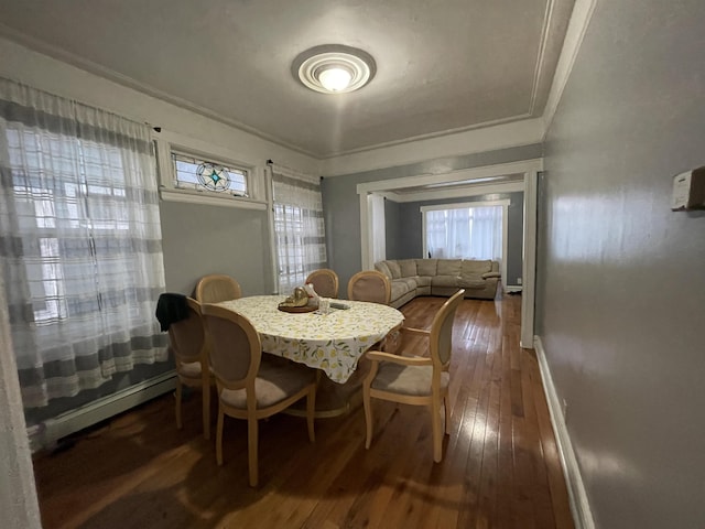 33 Clerk St, Jersey City, NJ 07305 - dining space with dark wood finished floors, a baseboard heating unit, crown molding, and baseboards