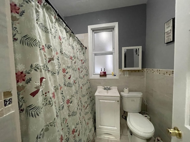 33 Clerk St, Jersey City, NJ 07305 - full bath with a sink, tile walls, toilet, tile patterned flooring, and wainscoting