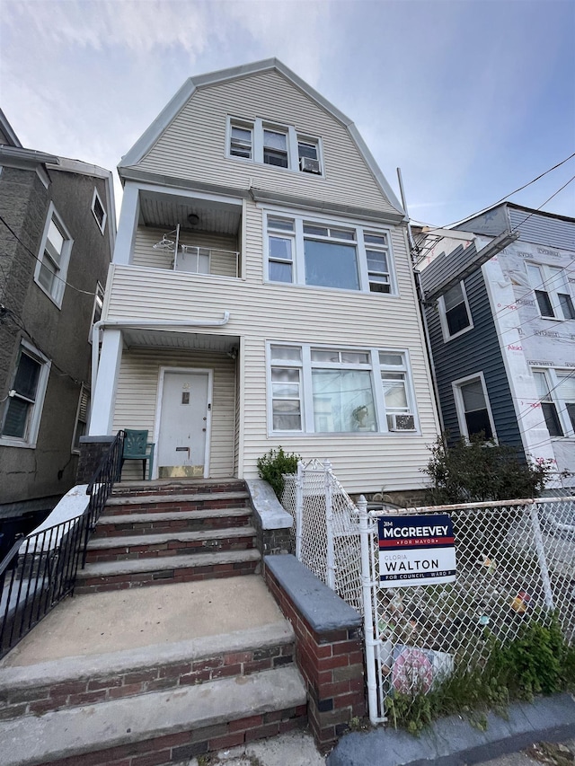 33 Clerk St, Jersey City, NJ 07305 - view of front of house with a gambrel roof, fence, and a balcony