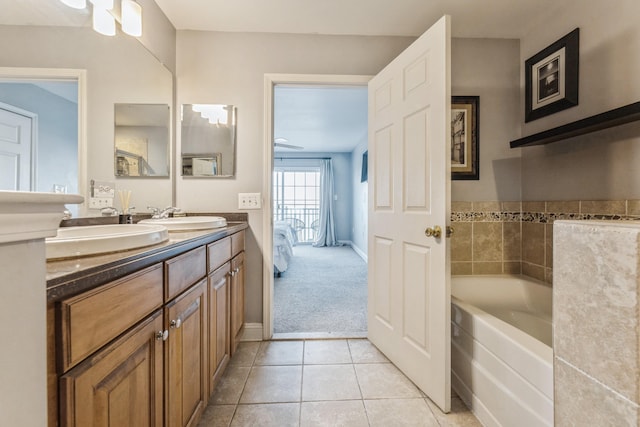 bathroom with ceiling fan, tile patterned floors, a tub to relax in, and vanity