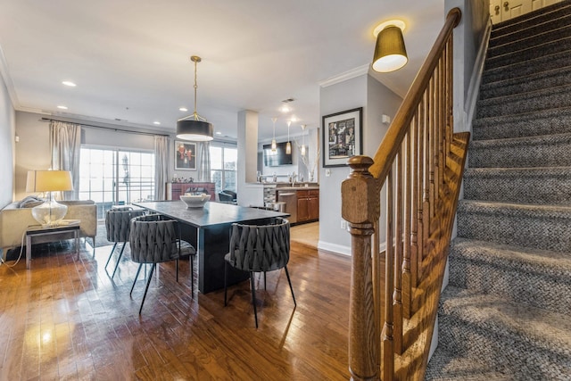 dining room featuring sink, dark wood-type flooring, and crown molding