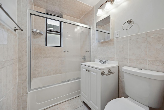 bathroom with toilet, tile walls, tile patterned flooring, enclosed tub / shower combo, and vanity