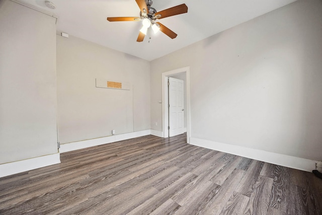 spare room with baseboards, wood finished floors, and a ceiling fan