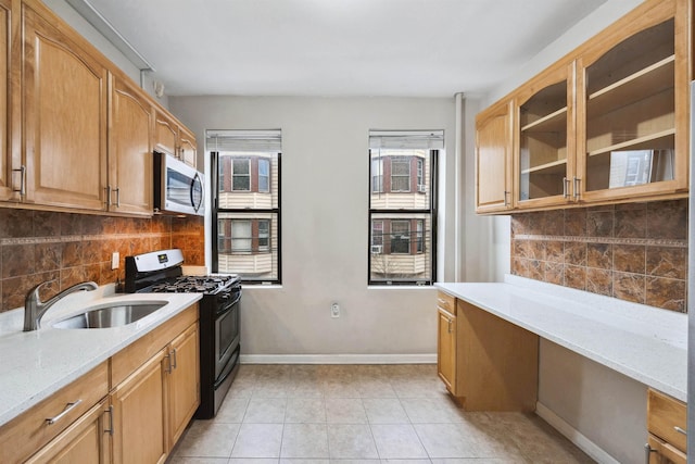 kitchen with a sink, light tile patterned floors, backsplash, and stainless steel appliances