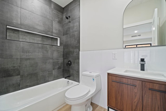 full bathroom with toilet, hardwood / wood-style flooring, bathing tub / shower combination, tile walls, and vanity