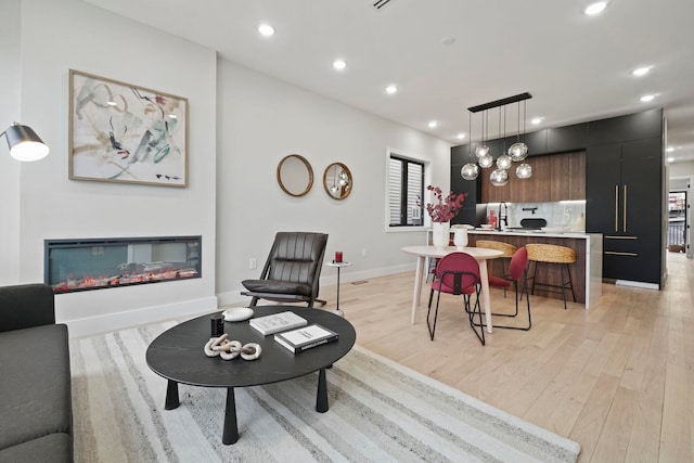 living room with light hardwood / wood-style floors and sink