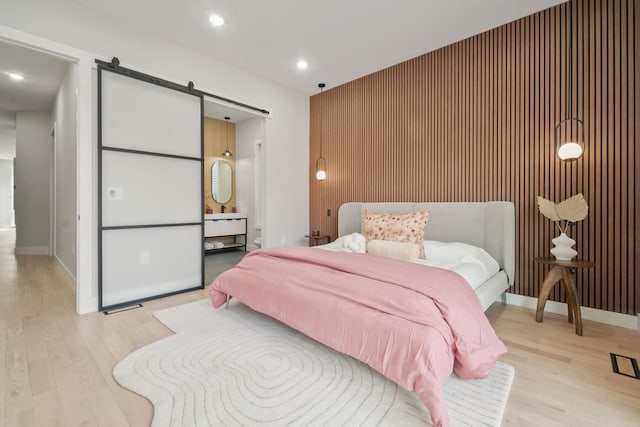 bedroom featuring light hardwood / wood-style floors and a barn door