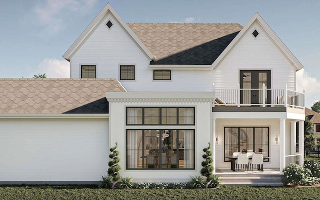back of house featuring a balcony, a shingled roof, and a garage