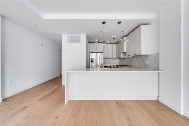 418 Monroe St Unit 201, Hoboken, NJ 07030 - kitchen with stainless steel fridge with ice dispenser, light countertops, a peninsula, decorative backsplash, and light wood-style floors