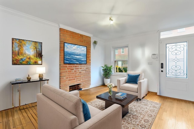 living room featuring crown molding, a fireplace, and light hardwood / wood-style floors