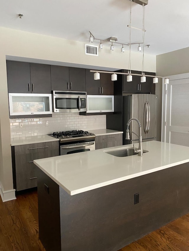 635 6th St Unit 2C, Hoboken, NJ 07030 - kitchen featuring appliances with stainless steel finishes, dark wood-style floors, modern cabinets, decorative backsplash, and light countertops