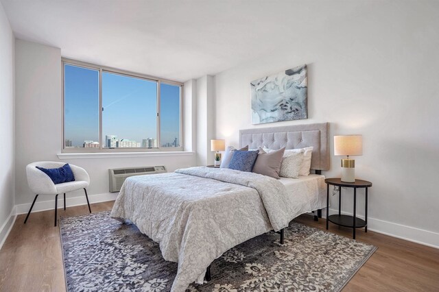 1 2nd St Unit 1012, Jersey City, NJ 07302 - bedroom with wood finished floors and a wall mounted AC