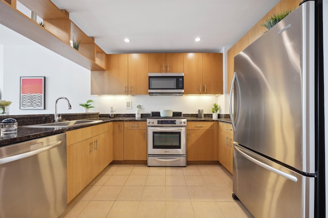 kitchen with dark stone counters, light tile patterned floors, open shelves, appliances with stainless steel finishes, and a sink